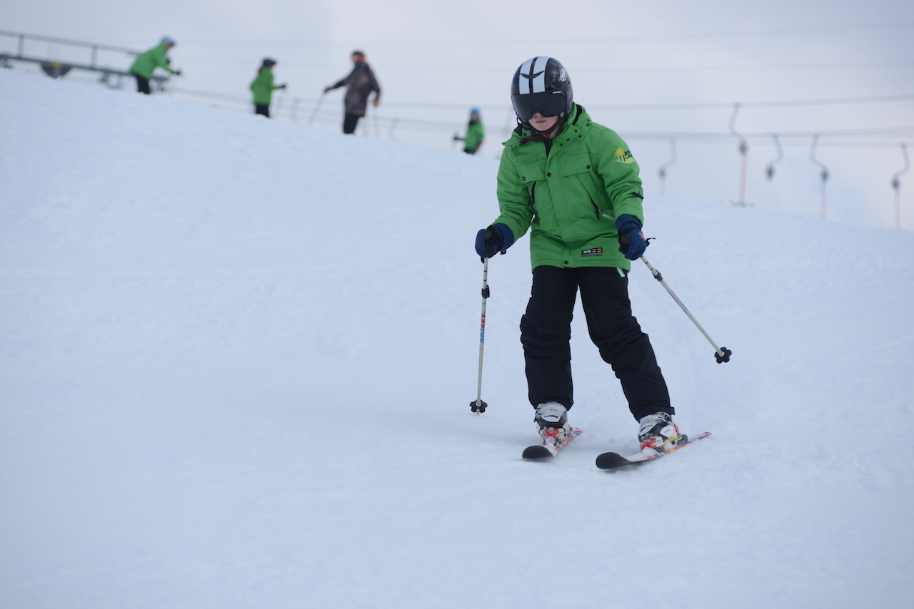 A camp participant skiing near the practice lift
