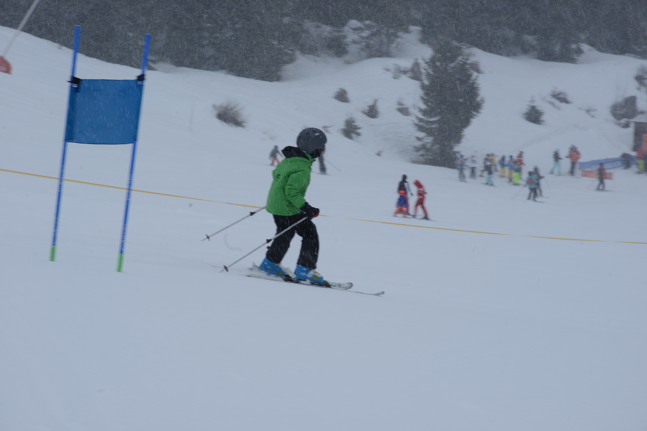 A skier on the training course with the group waiting below