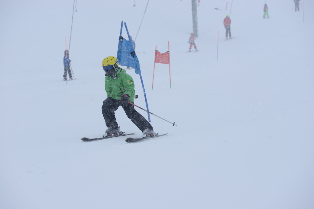 A camp participant skiing down a groomed run