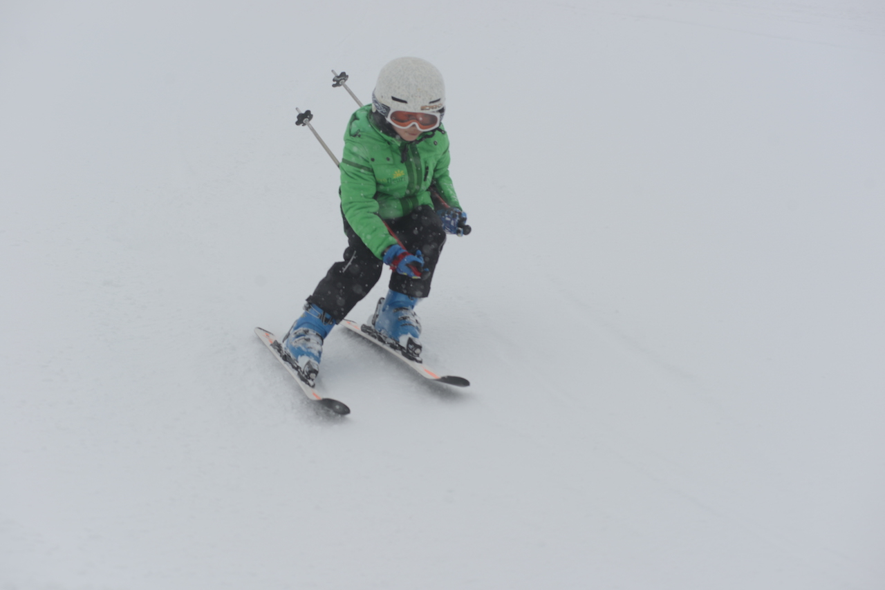 A young skier practising turns on a gentle slope