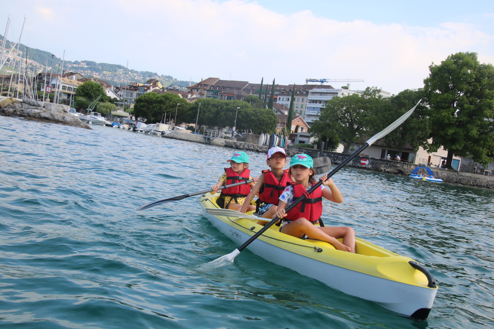 A camp kayak on Lake Geneva with the lakeside town behind