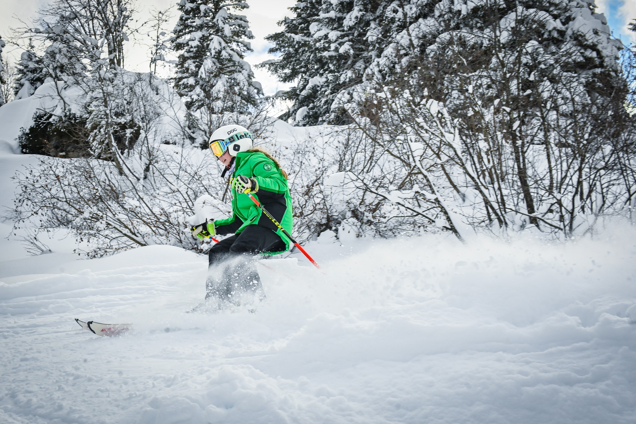 A young skier making turns through deep snow